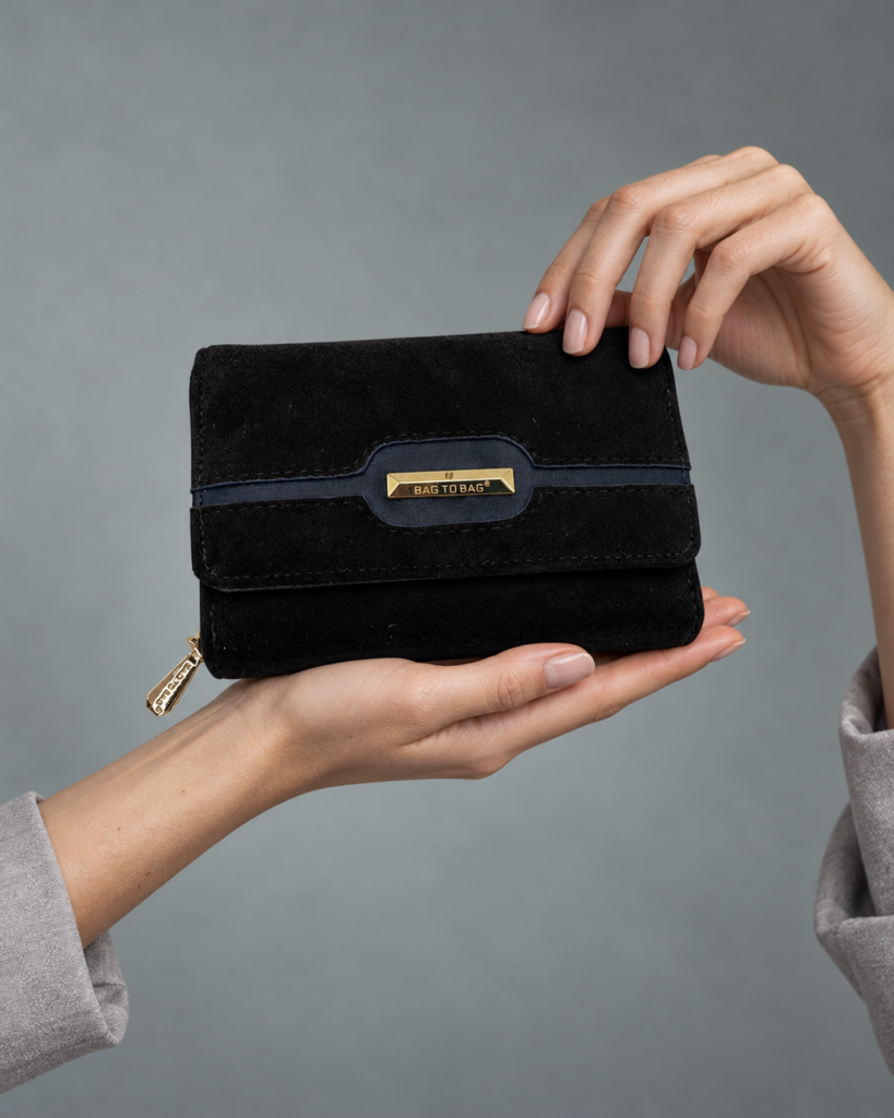 Σκούρο πορτοφόλι BagToBag YC03128 με χρυσή μεταλλική λεπτομέρεια, σε κοντινή φωτογράφιση χεριών σε γκρι studio